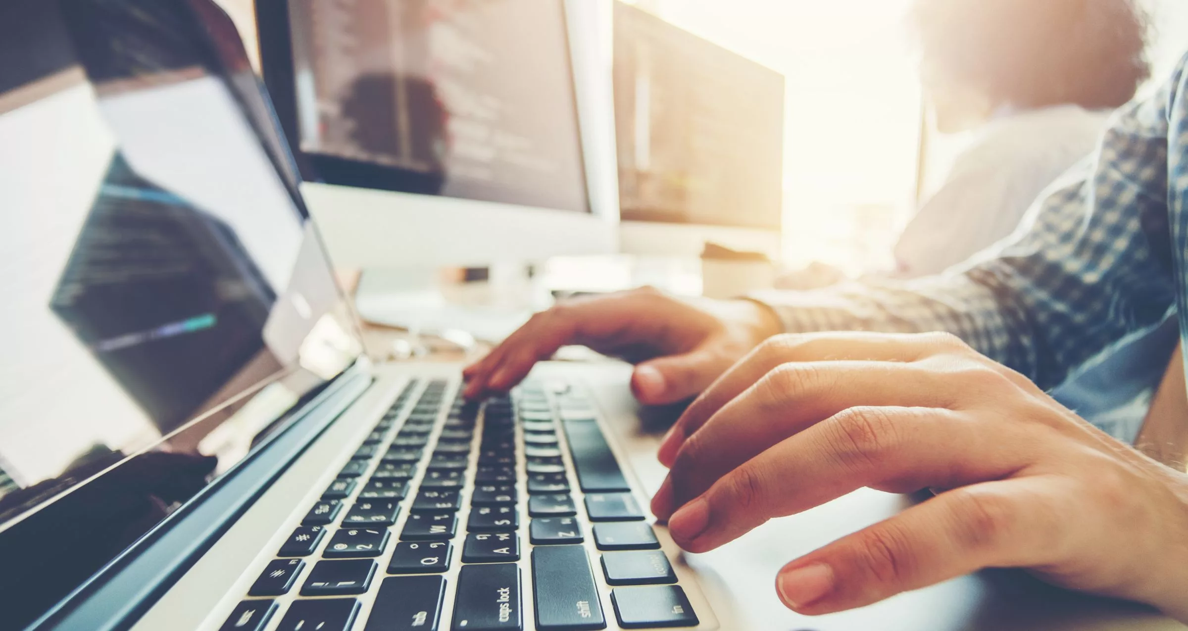 Image of a mans hands typing on a laptop keyboard - accompanies blog post about how to grant admin access to your wordpress site