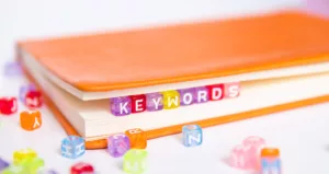 A book with beads that spell the word Keywords inside the pages.