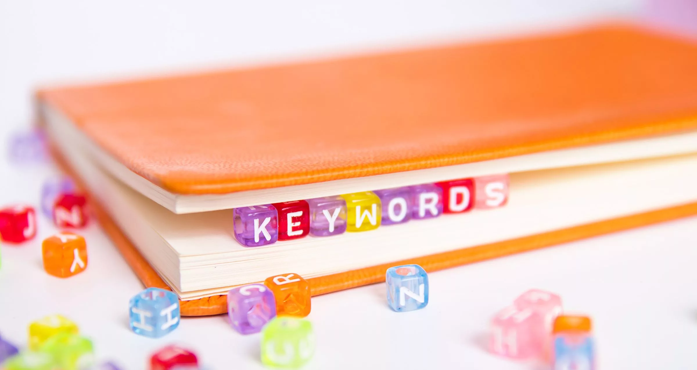 A book with beads that spell the word Keywords inside the pages.